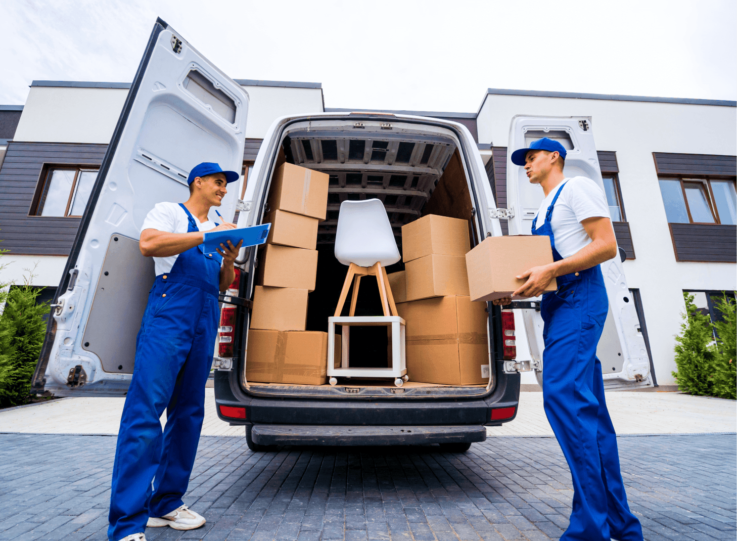 Two delivery workers reviewing paperwork at a moving van