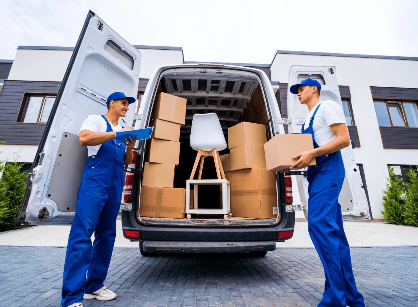 Two delivery workers reviewing paperwork at a moving van