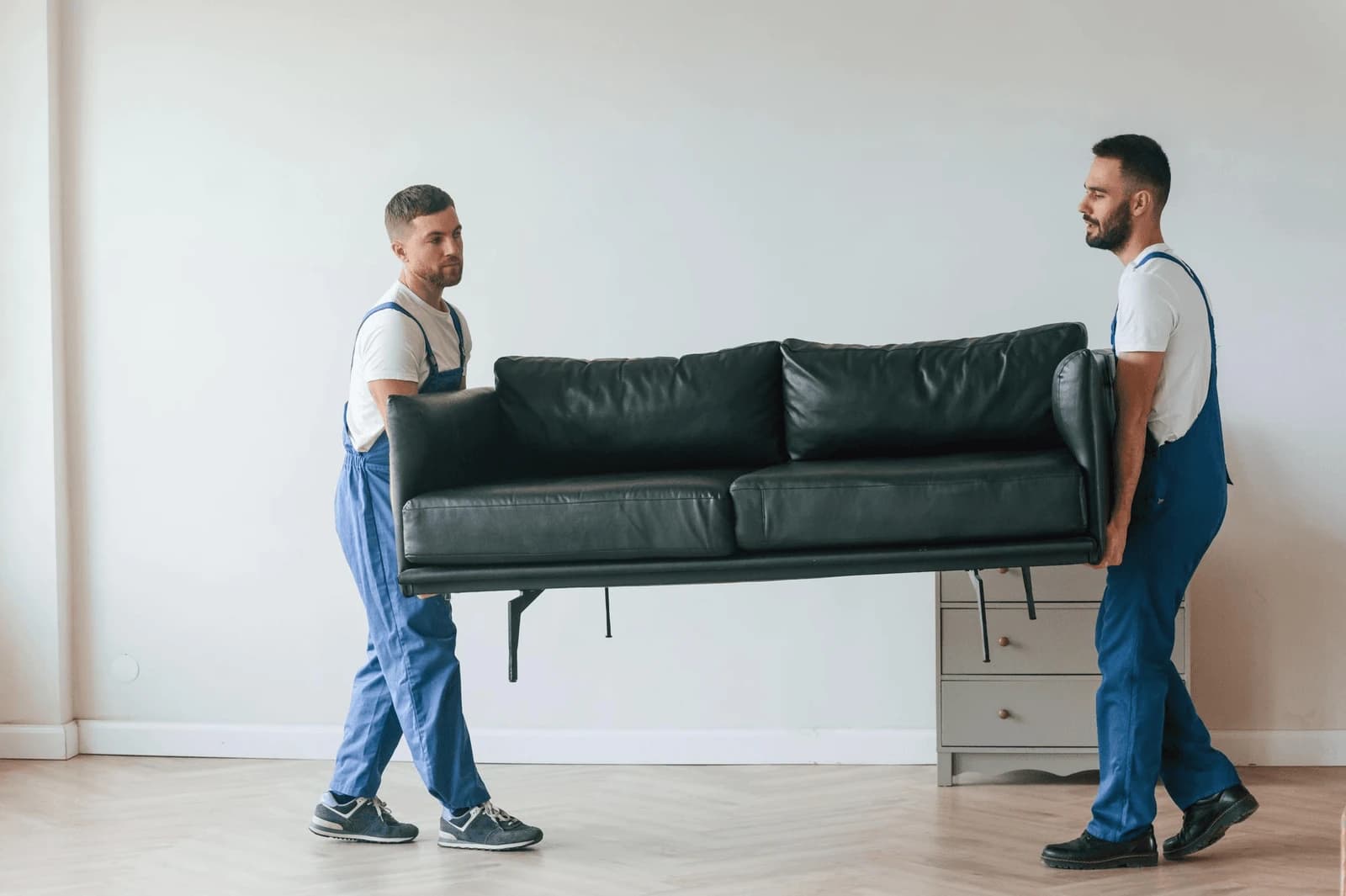 Cream sofa with cushions removed — ready for disassembly during delivery.