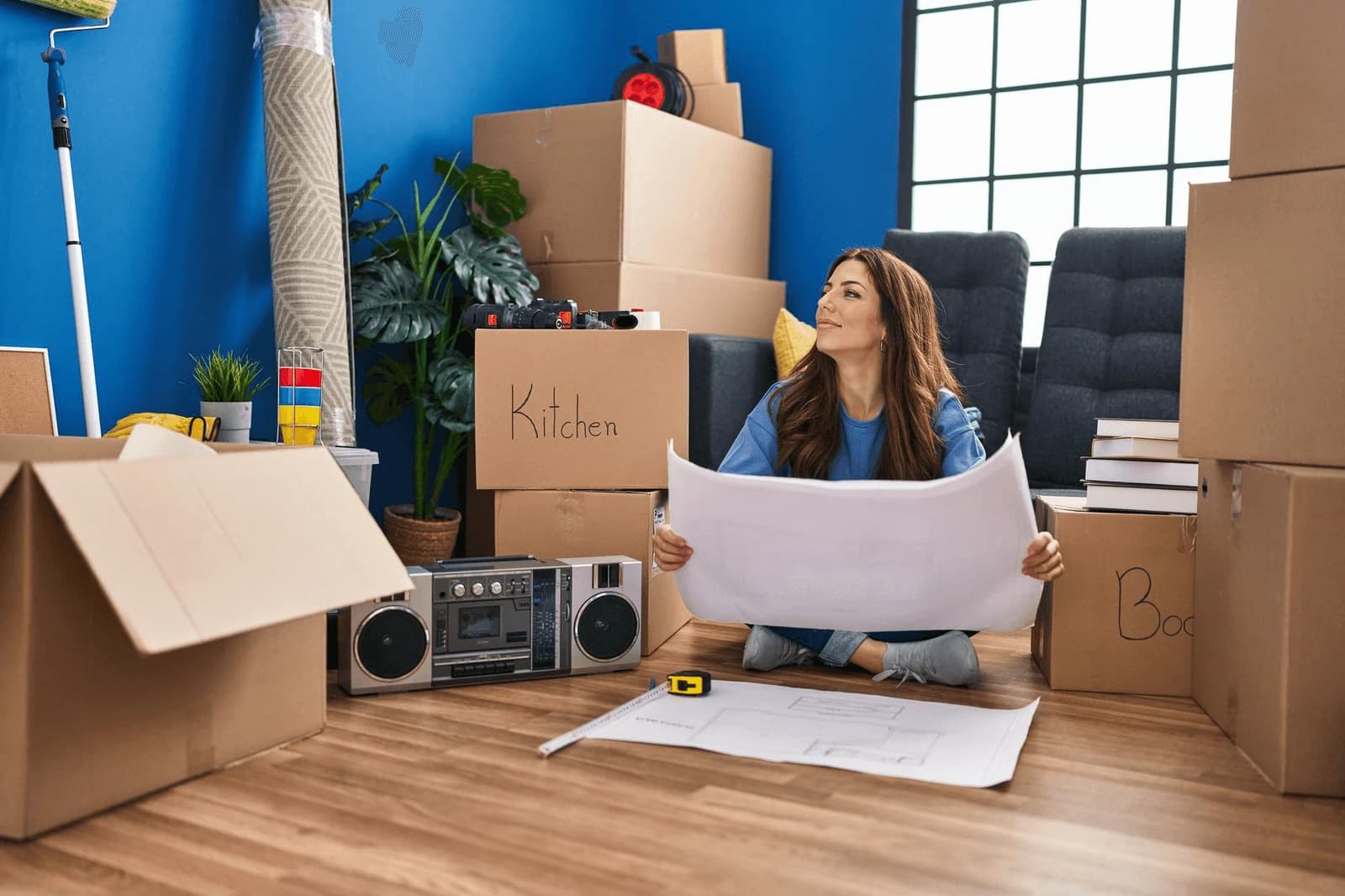 Customer reviewing a floor plan among labelled moving boxes at home